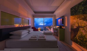Une chambre d’hôtel moderne, dotée d’un grand lit, d’un bureau et d’une télévision.