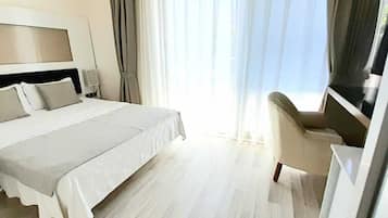 A hotel room with a bed, a desk, and a TV.
