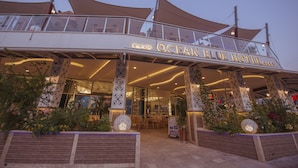L’extérieur de l’hôtel Ocean Blue se caractérise par son entrée abritée, ses grandes fenêtres et ses colonnes décoratives.