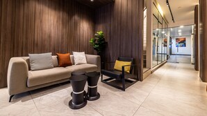 A modern lobby with a sofa, a chair, and a plant. - Citrus Patong Hotel by Compass Hospitality (Patong)