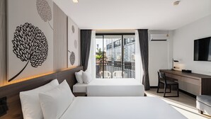 A modern hotel room with two beds, a desk, and a balcony with a view of the city. - Citrus Patong Hotel by Compass Hospitality (Patong)