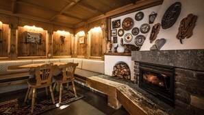 Een gezellig interieur met een open haard, houten wanden en een bank.