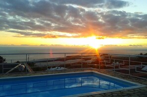 A swimming pool with a view of the sunset over the ocean. - Residencial Las Norias (Los Llanos de Aridane)