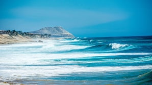 A coastal landscape with a mountain and ocean waves. - Hyatt Place Los Cabos (San José del Cabo)