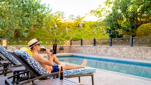 A poolside area with lounge chairs and a table. - Hyatt Place Los Cabos (San José del Cabo)