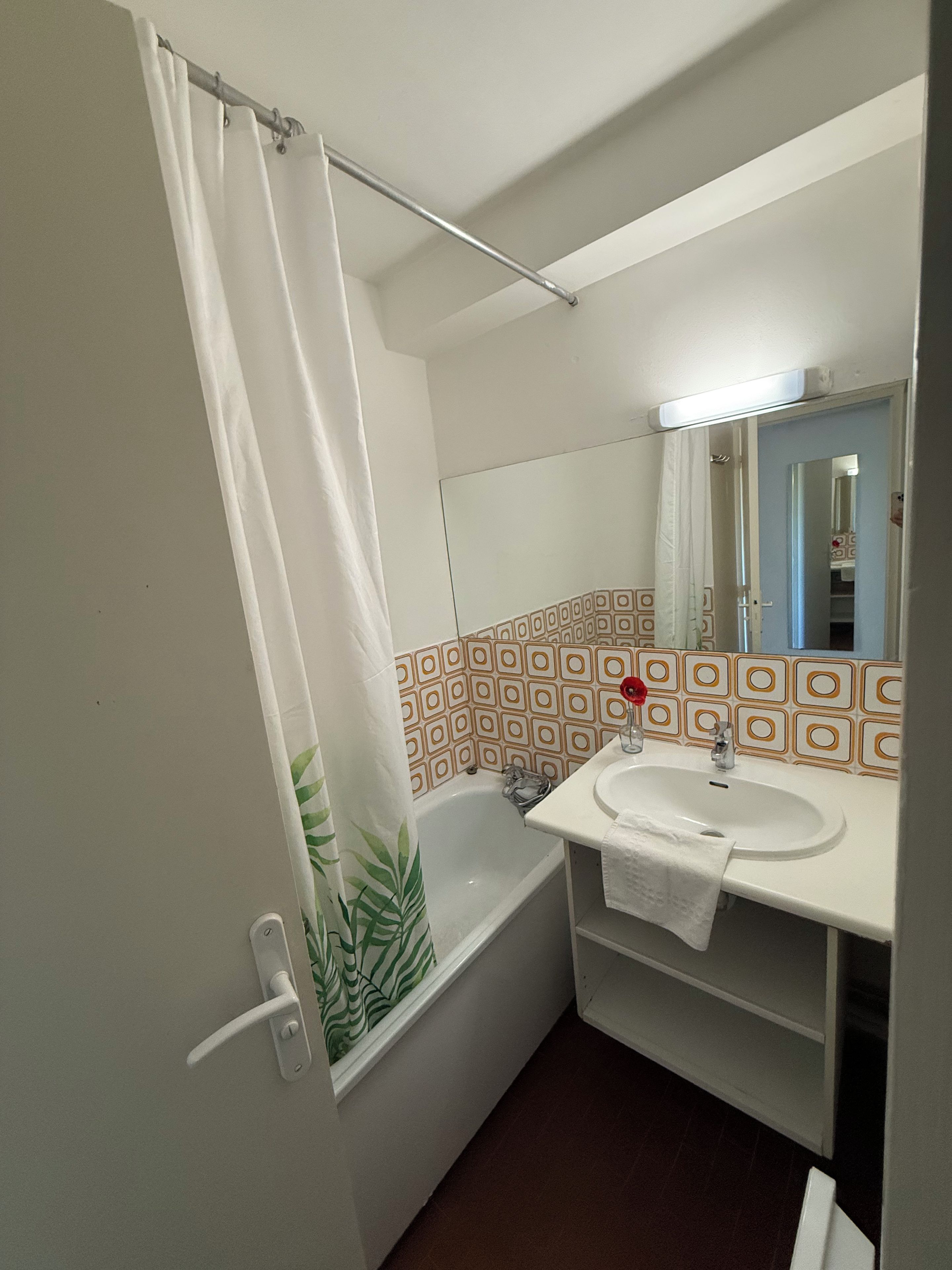 A bathroom with a bathtub, a sink, and a mirror.