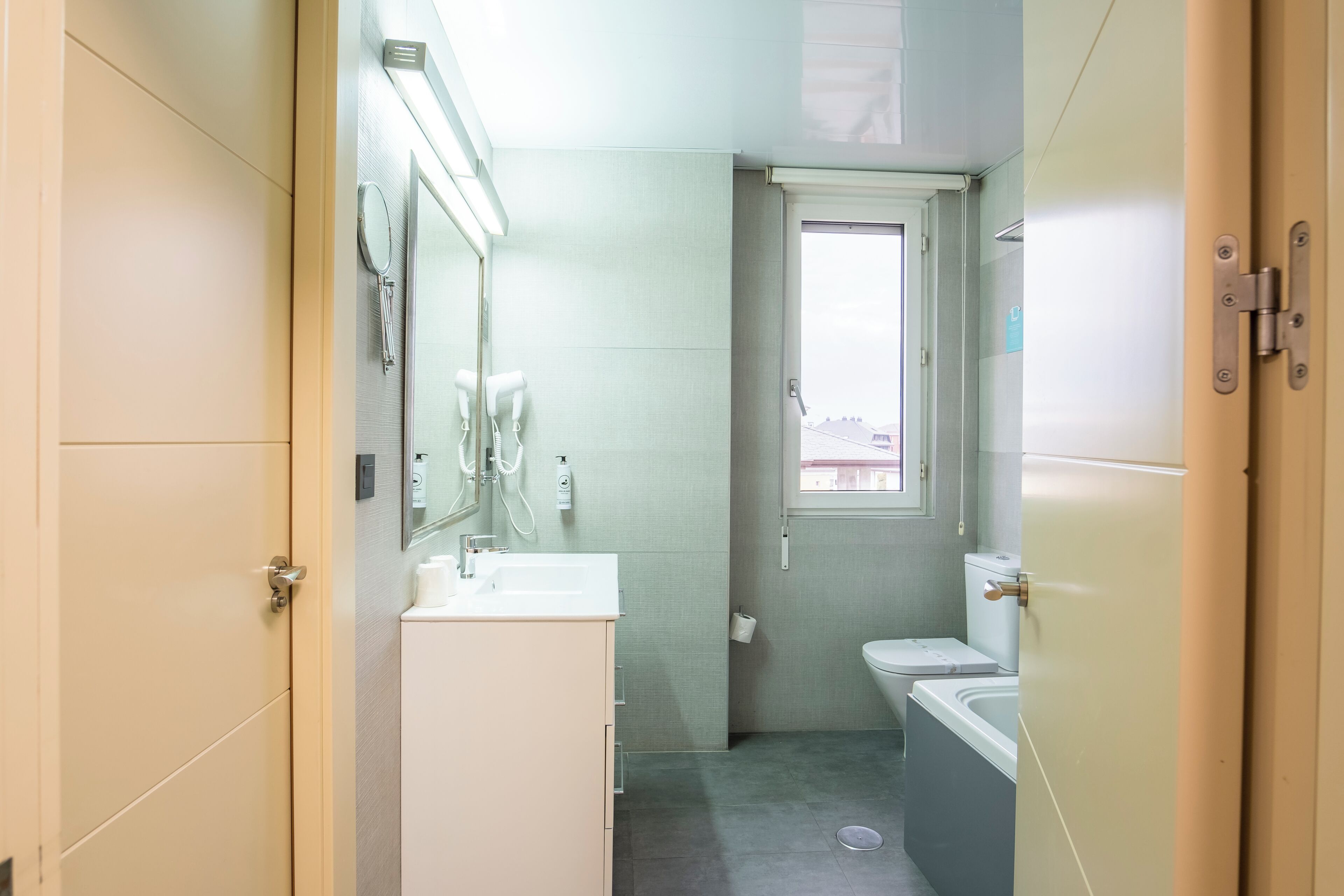 Un baño pequeño con lavamanos, espejo e inodoro.