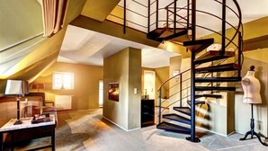 Un loft espacioso con una escalera espiral, un ventanal grande y una zona de estar acogedora.