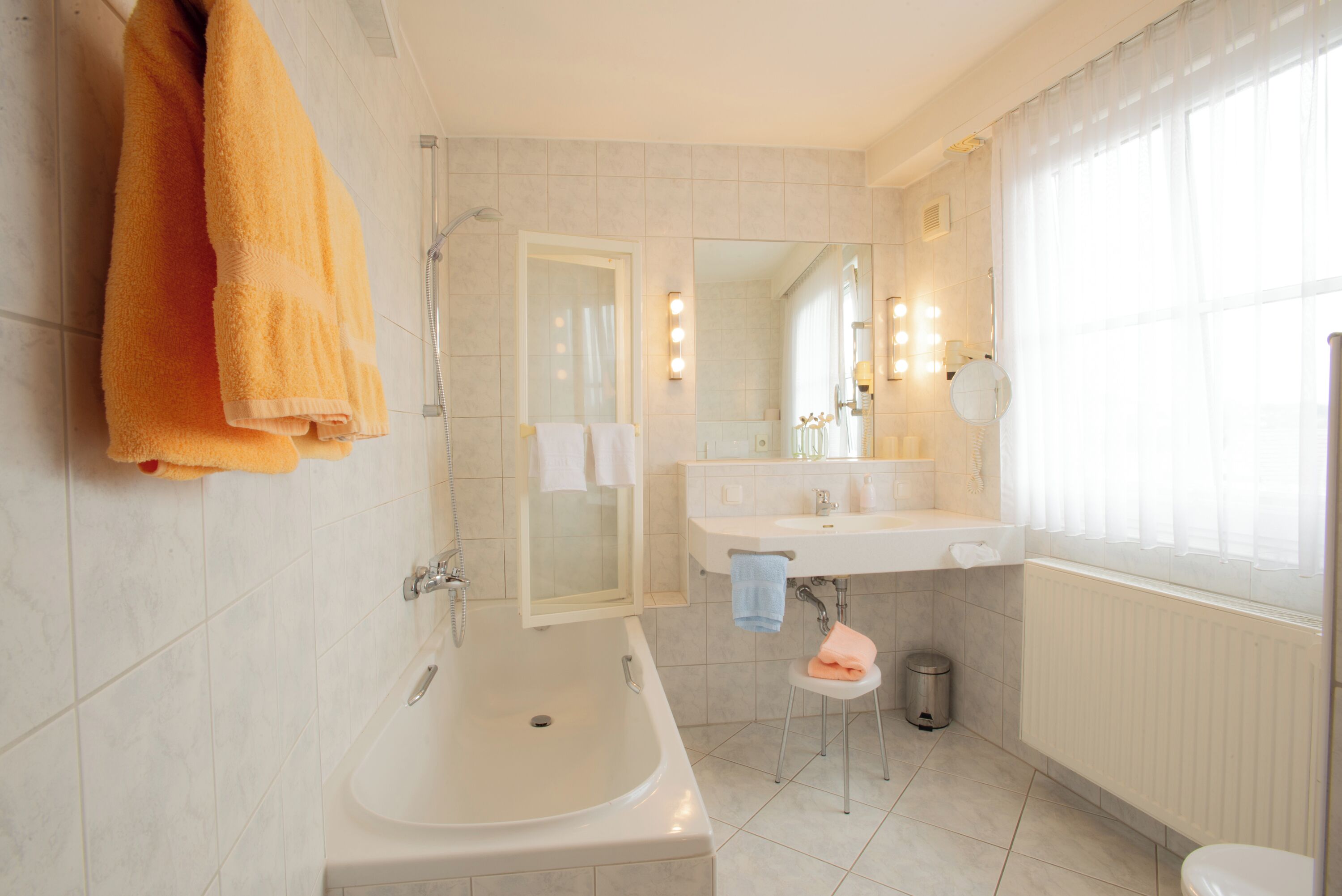 Ein modernes Badezimmer mit einer Badewanne, einem Waschbecken und einem Spiegel.