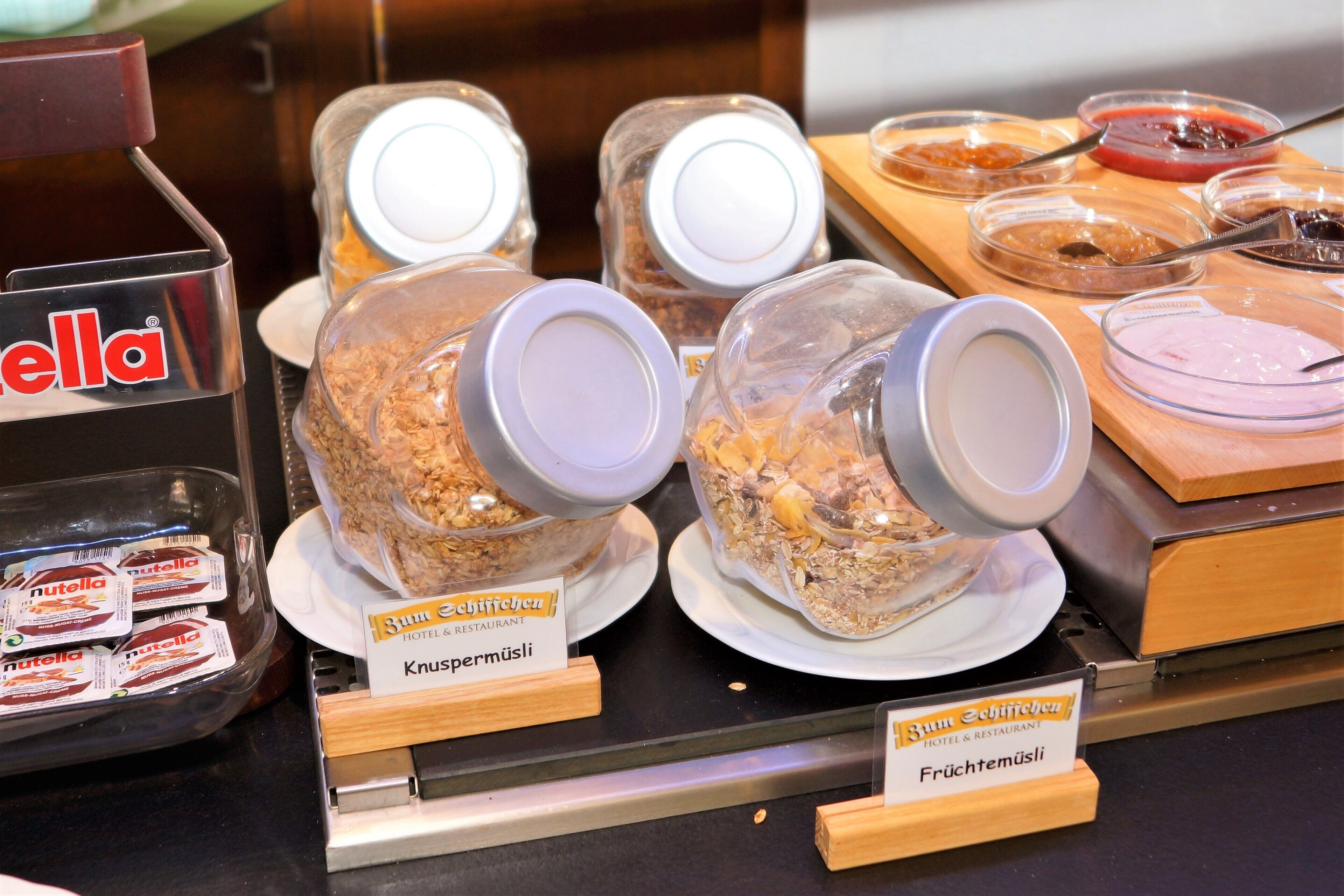 A buffet area with various food items and condiments.