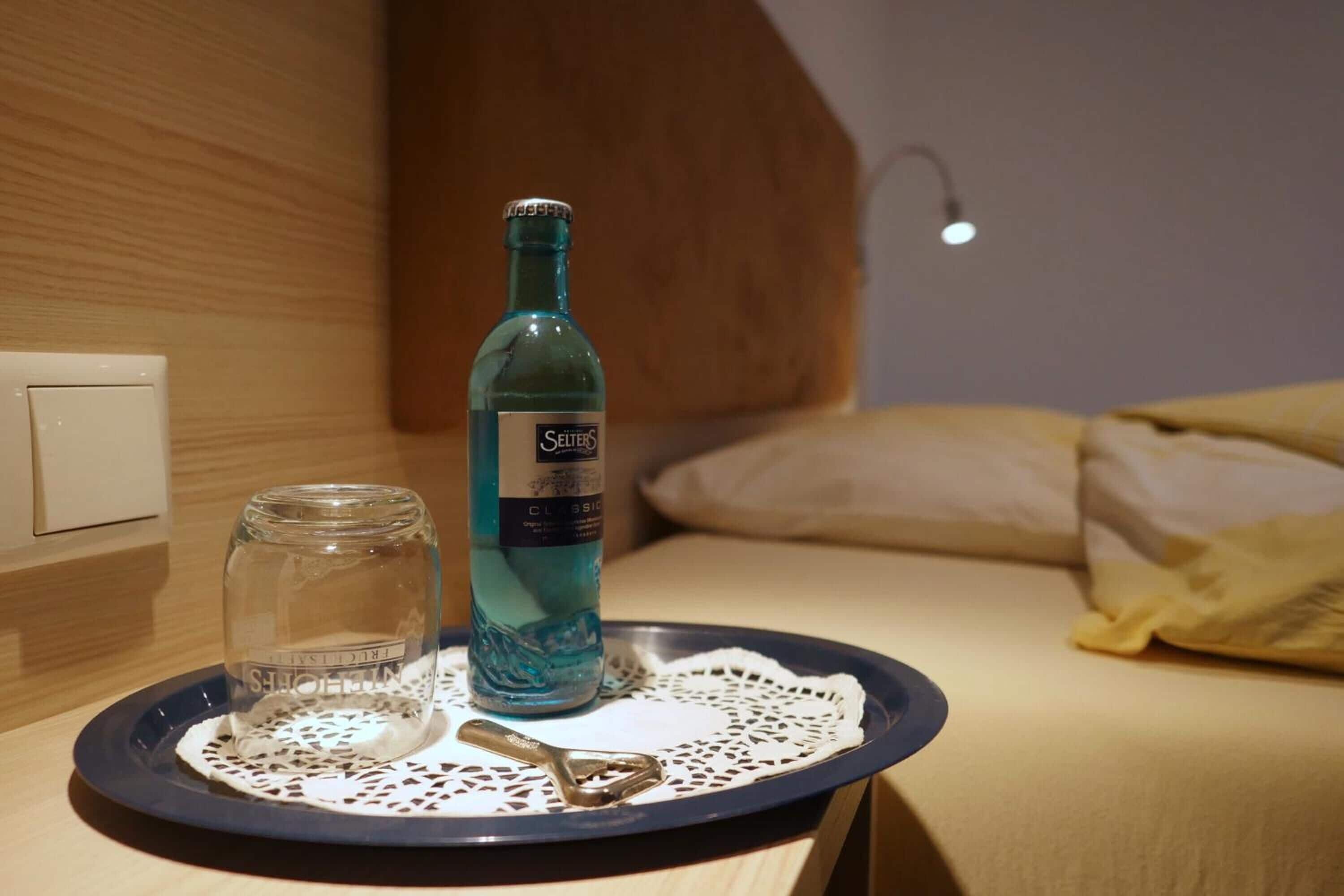 A bottle of Selters Classic on a tray with a glass jar and a spoon.