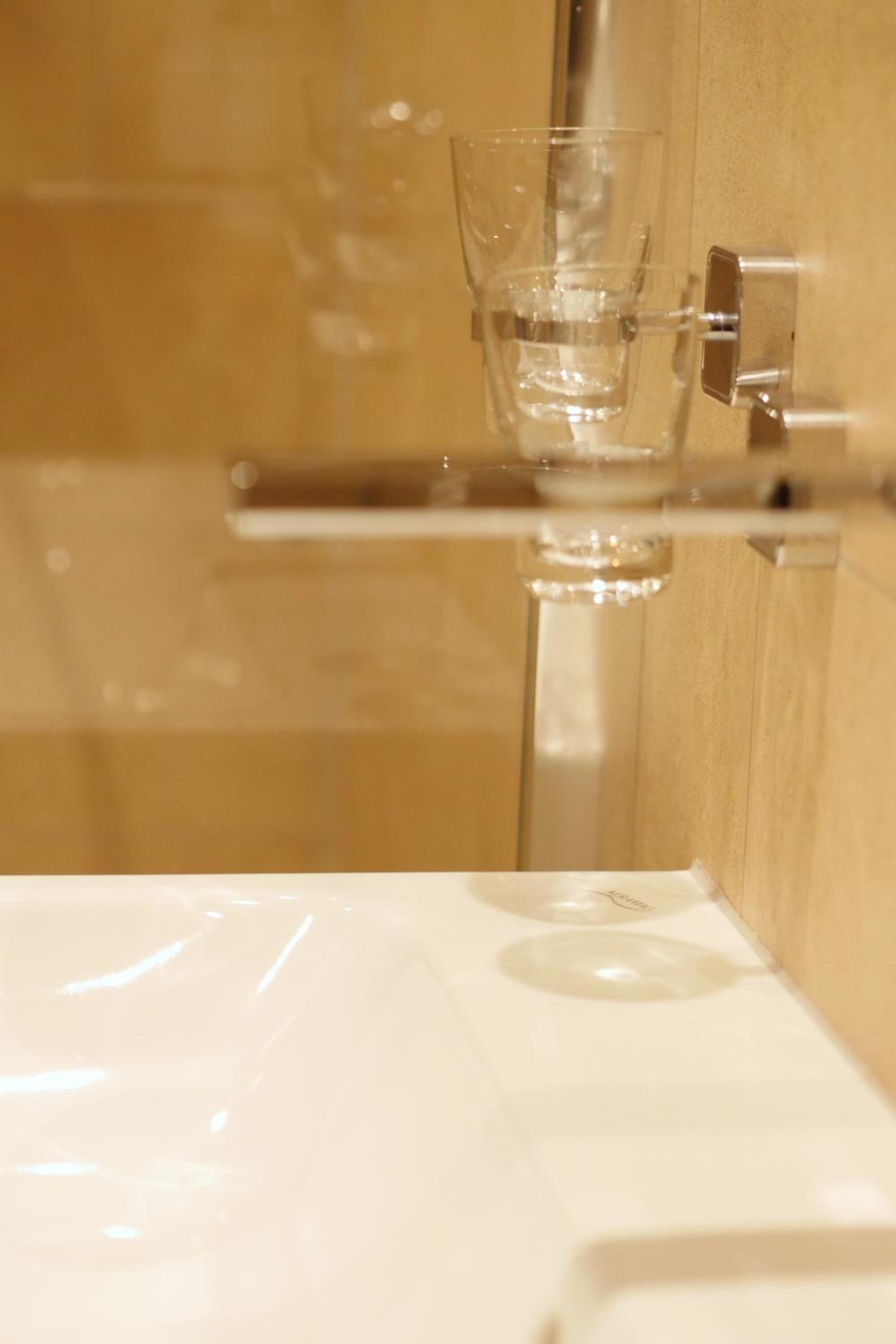 Un baño con cabina de ducha de vidrio y lavamanos blanco.