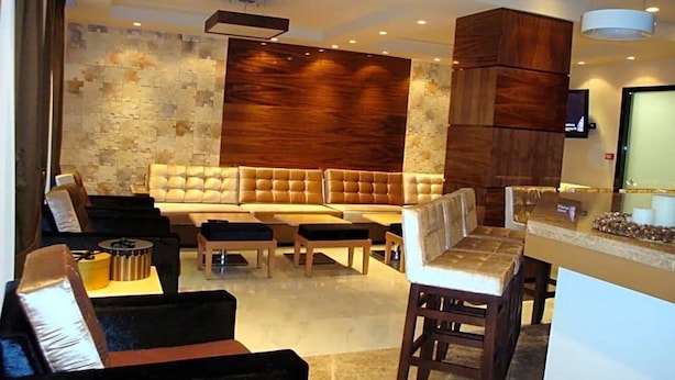 Una sala de estar moderna con un sofá modular grande, una mesa de centro y una zona de bar con taburetes.