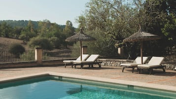 Una piscina al aire libre, tumbonas