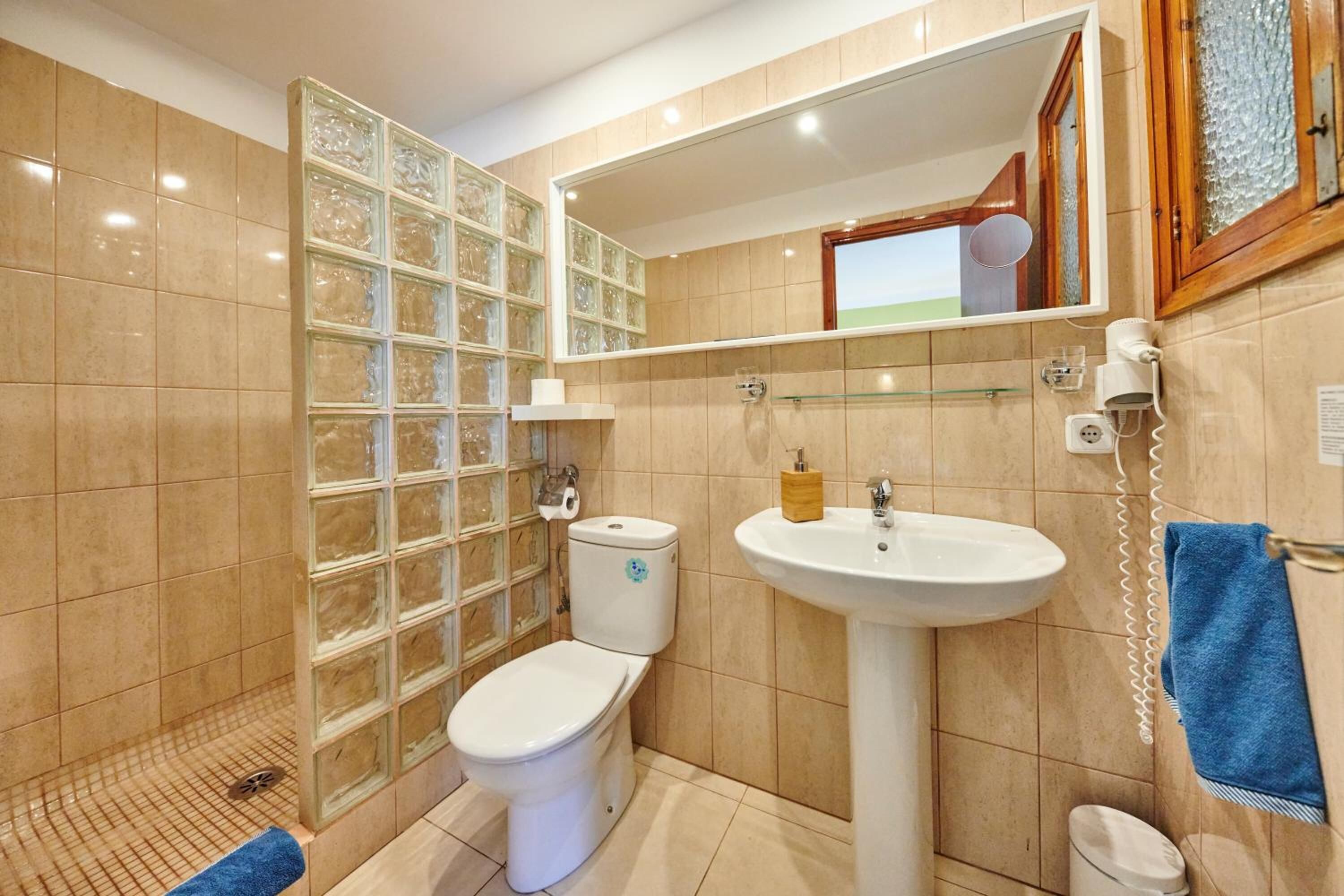Une salle de bain équipée de toilettes, d’un lavabo et d’une douche à parois en verre.