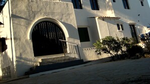 Un bâtiment blanc doté d’une grande entrée en arc de cercle, de nombreuses fenêtres et d’un petit balcon.