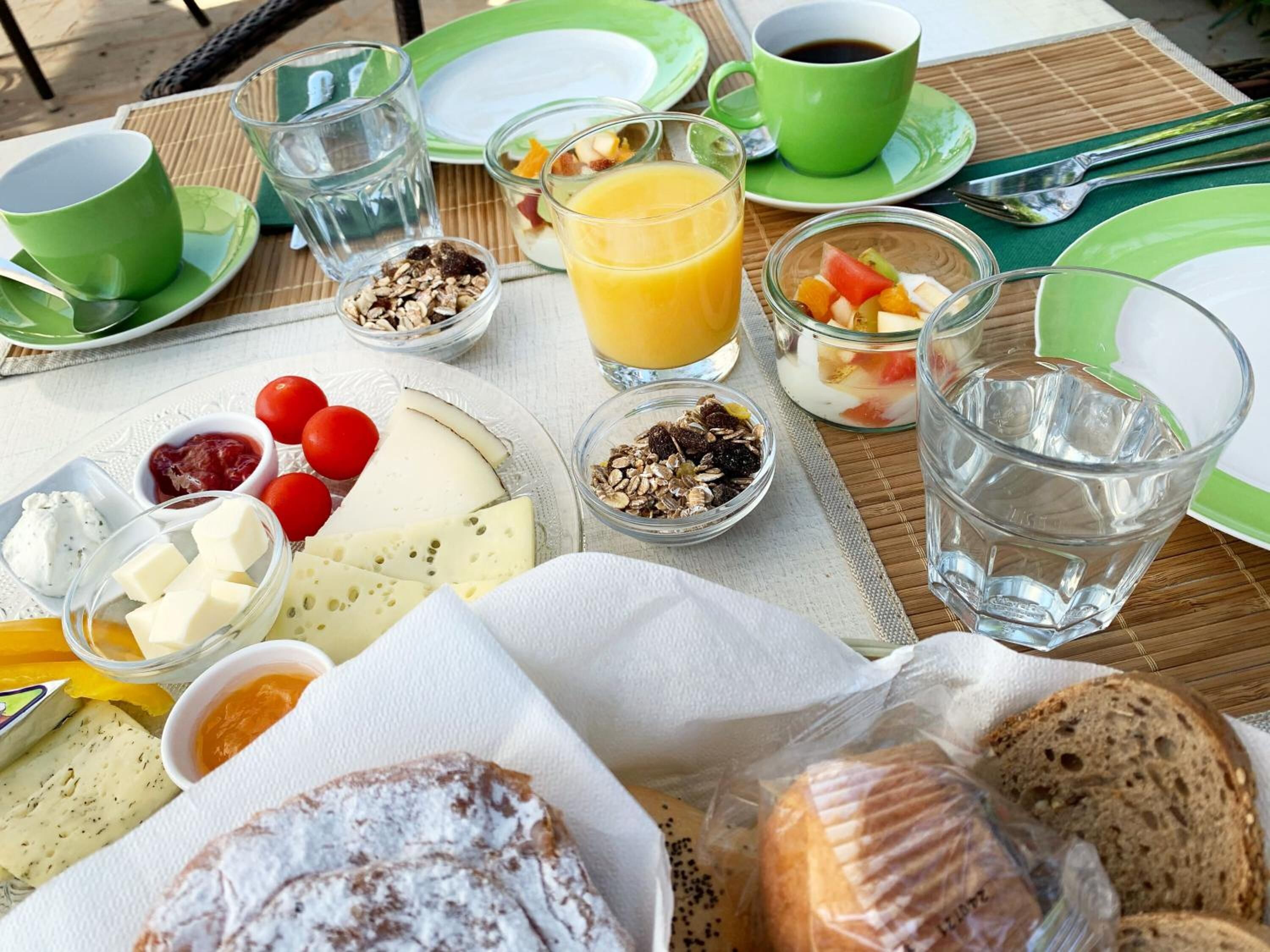 A breakfast setting with various food items and drinks on a table.