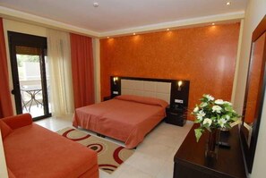 A hotel room with two beds, a desk, a chair, and a large window. - Astir Notos (Thasos)