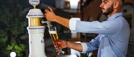 A person pouring beer from a tap labeled 'KULMBACHER' into a glass.