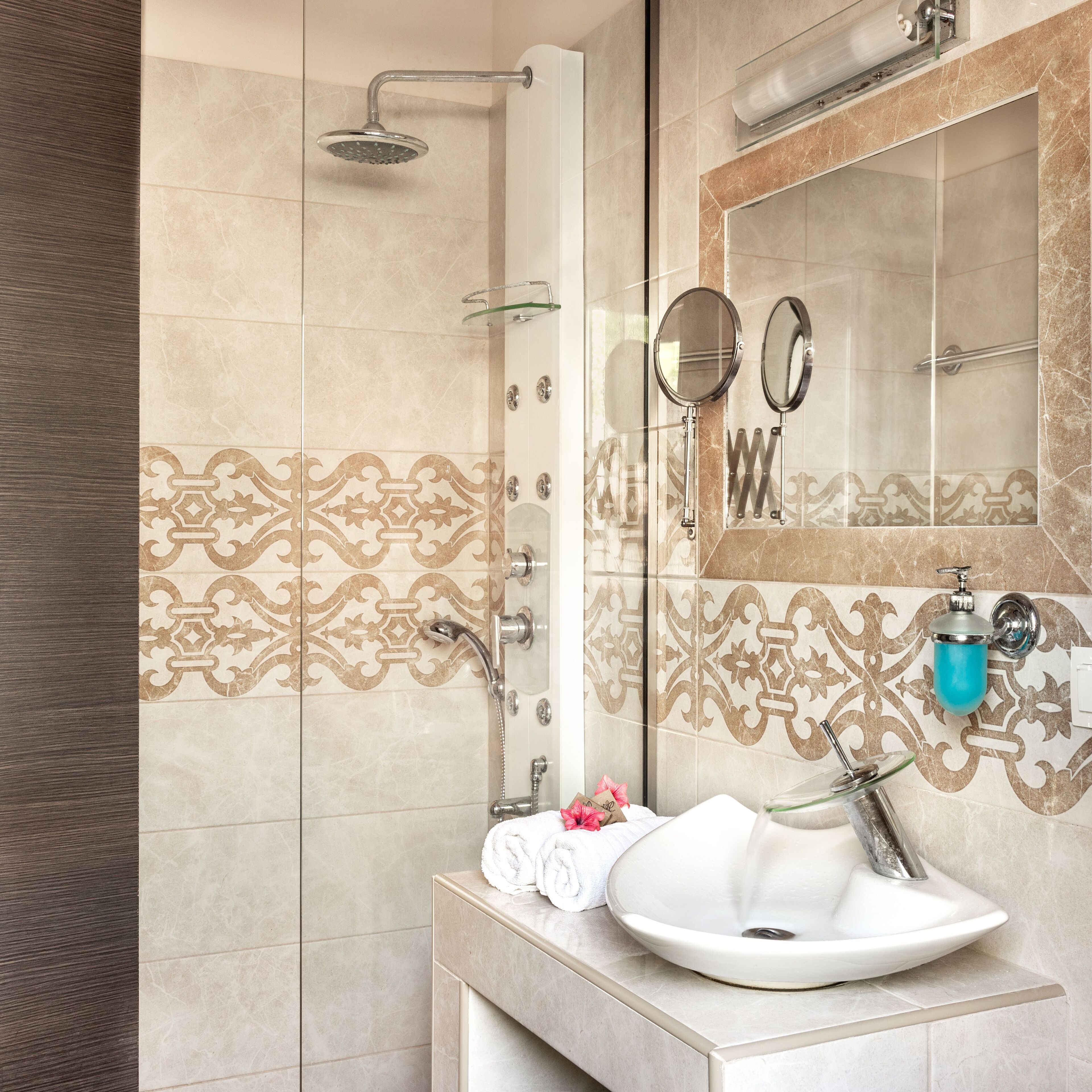 A bathroom with a shower, a sink, a mirror, and a towel.