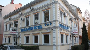 Een gebouw met het bord 'Tisza Alfa Hotel', wat aangeeft dat het een hotel is.