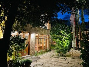 A house with a stone exterior, a glass door, and a stone pathway leading to the entrance. - Hotel Shambhala Resort (Leh)