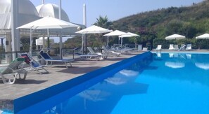 A swimming pool with lounge chairs and umbrellas. - Le Terrazze Residence & Resort (Agropoli)