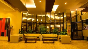 A modern lobby with a seating area, large windows, and a staircase. - Capitol Hill (Ranchi)