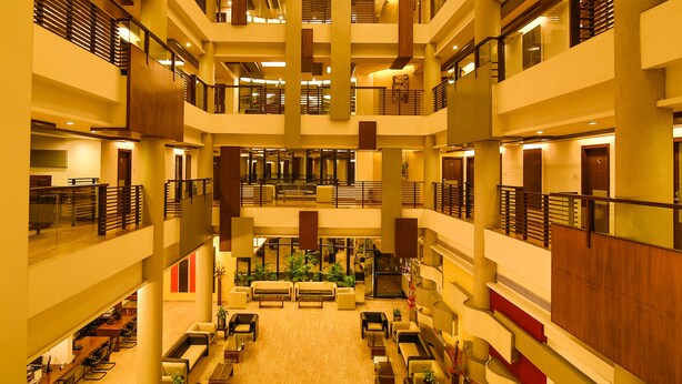 A multi-level hotel lobby with a central seating area, multiple floors, and a modern architectural design. - Capitol Hill (Ranchi)