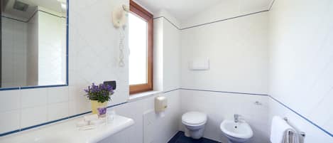 Un baño con bañera, inodoro y bidé.