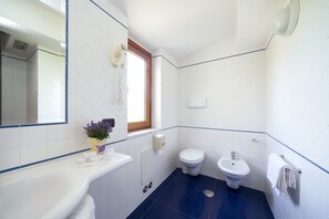 A bathroom with a bathtub, a toilet, and a bidet.
