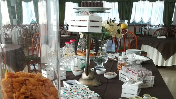 A buffet table with various food items and a large container of snacks. - Hotel Ristorante La Piana (Amorosi)