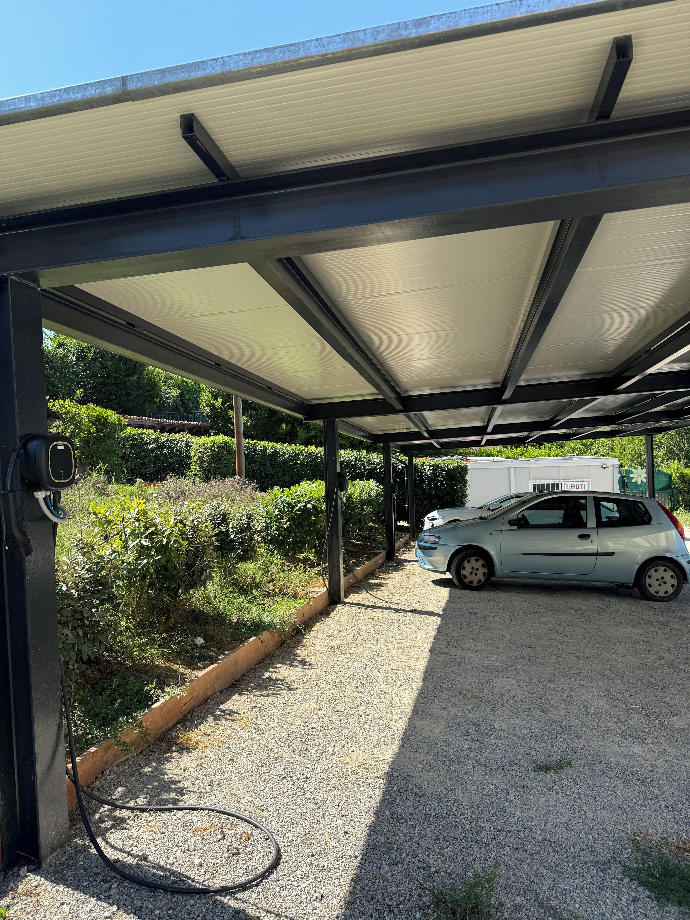 A covered parking area with a car parked under a canopy.