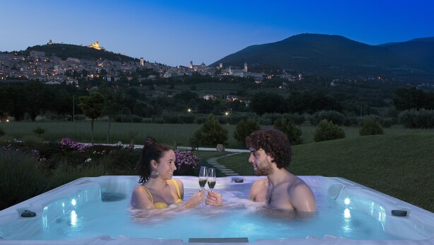 A couple in a hot tub with a cityscape in the background. - All'Antica Mattonata (Assisi)
