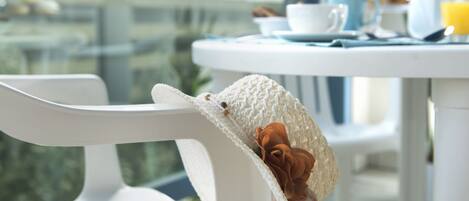 Una silla blanca con un gorro tejido y una flor.