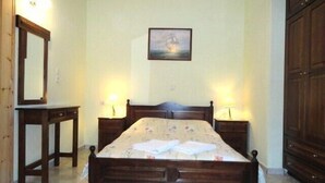 Un dormitorio con una cama de madera, dos mesitas de noche con lámparas, un espejo y un cuadro en la pared.