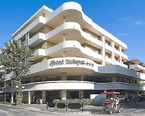 A multi-story hotel with a curved facade and balconies.