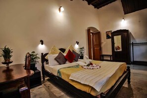 Quarto bem arrumado com uma cama, mesas de cabeceira, um espelho e uma porta.
