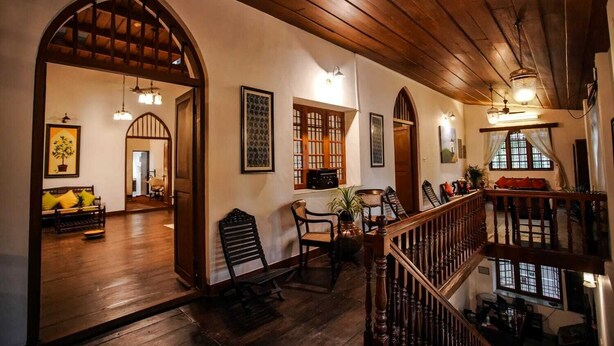 Un interior amplio con suelo de madera, una escalera y un balcón.