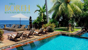 A poolside area with lounge chairs, a statue, and a view of the ocean. - Villa Boreh Beach Resort and Spa (Tejakula)