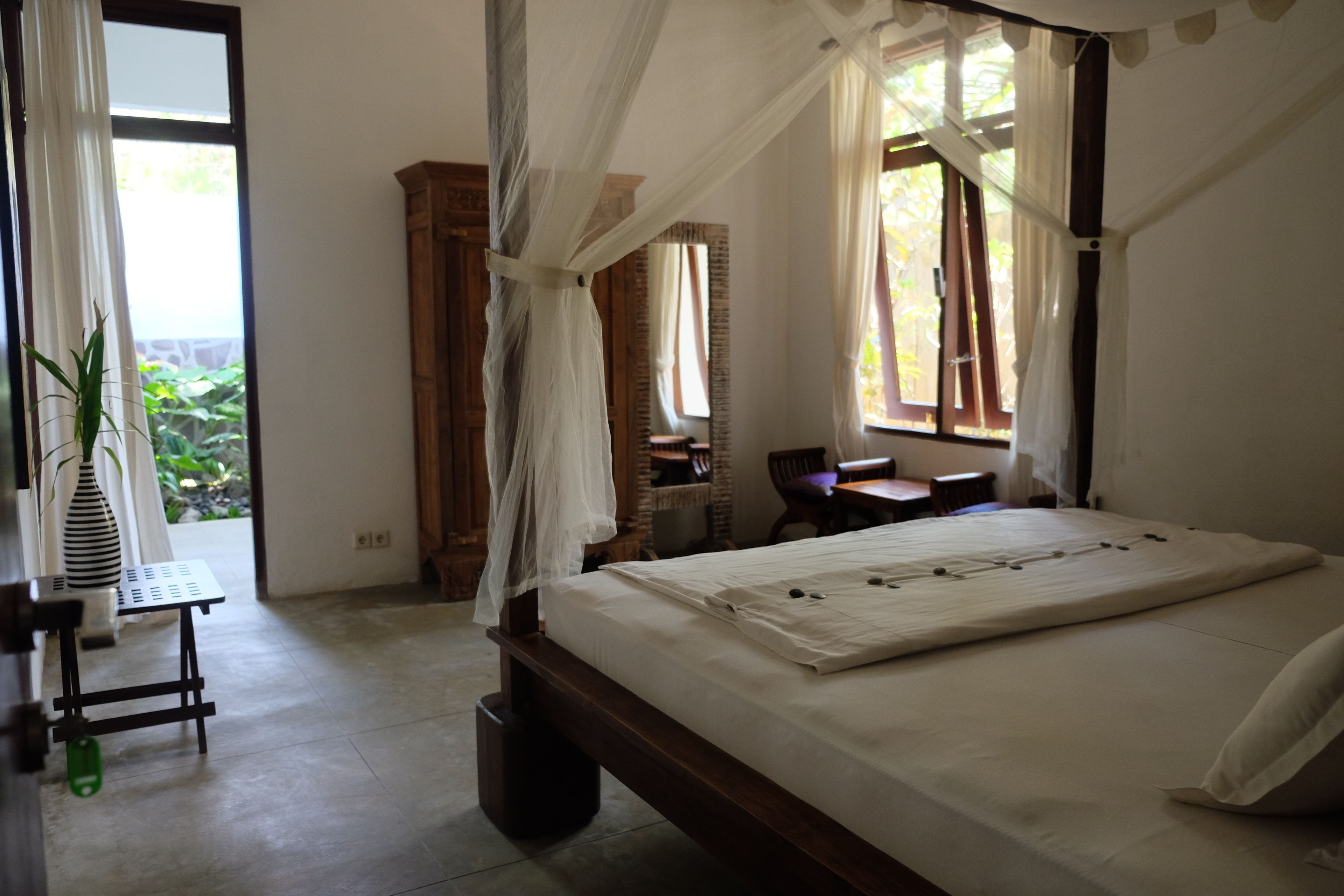 Un dormitorio con cama con dosel, un escritorio y una silla.