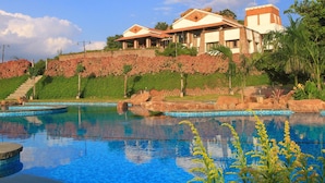 Un hotel con piscina, jardín ajardinado y vistas del entorno.