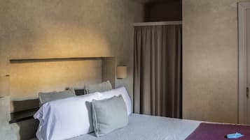 Un dormitorio con cama, cabecero, mesita de noche, lámpara y lámpara colgante.