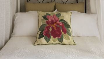 Una cama con dosel, cabecera y almohada decorativa.