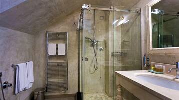 Ein modernes Badezimmer mit einer begehbaren Glasdusche, einem мраморному Waschbecken und einem großen Spiegel.