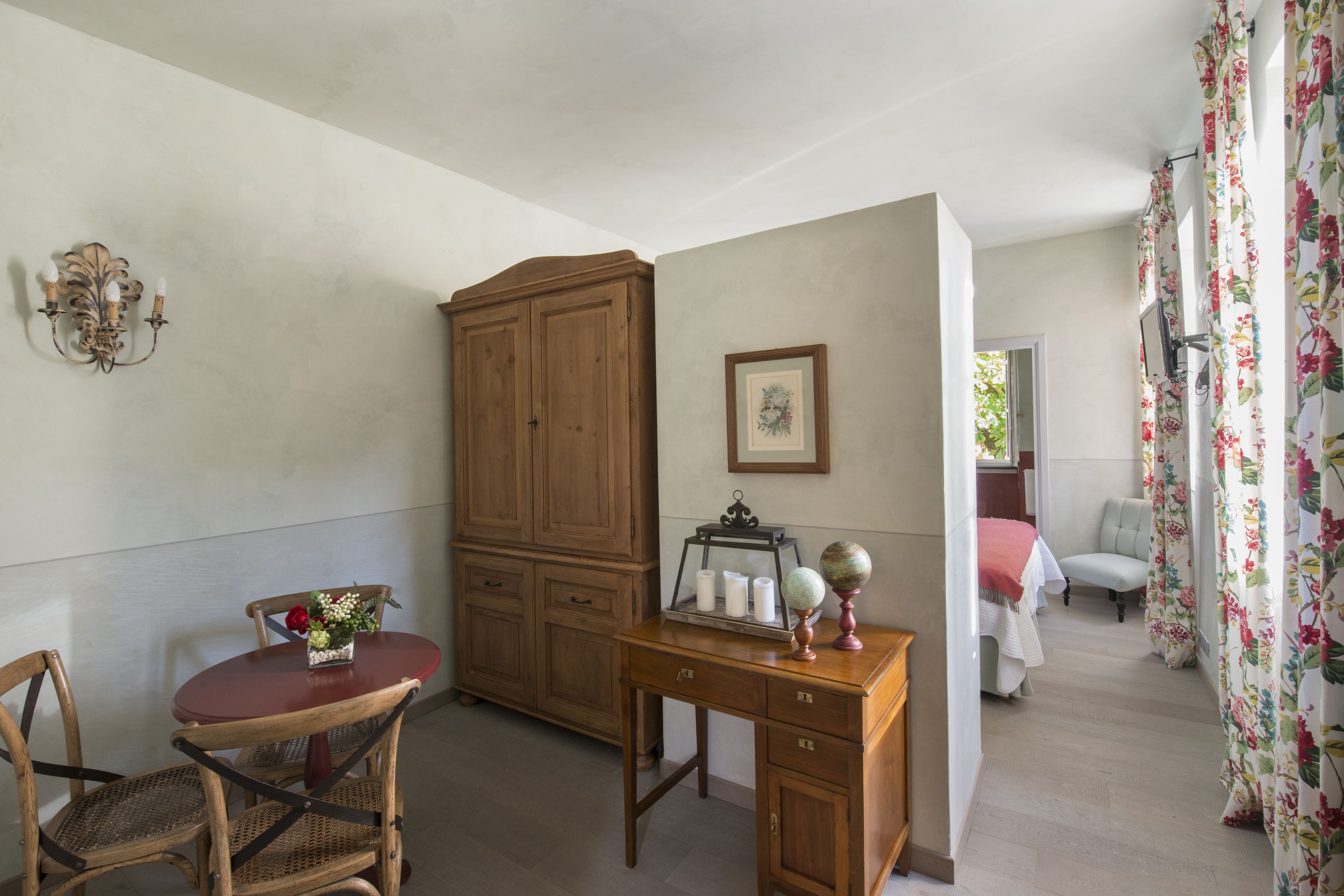 Una habitación con escritorio de madera, una silla, un armario y una cama.