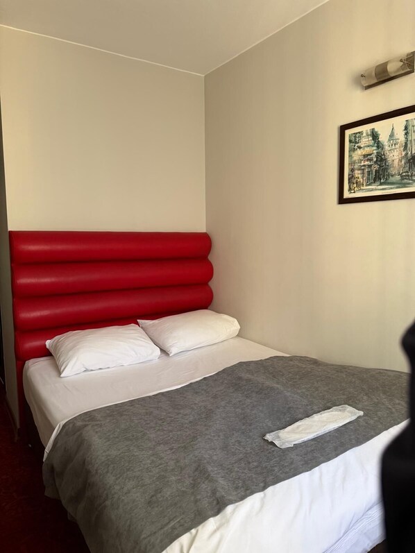 A single bed with a red headboard, white pillows, and a grey blanket. - Timya Hotel (Istanbul)