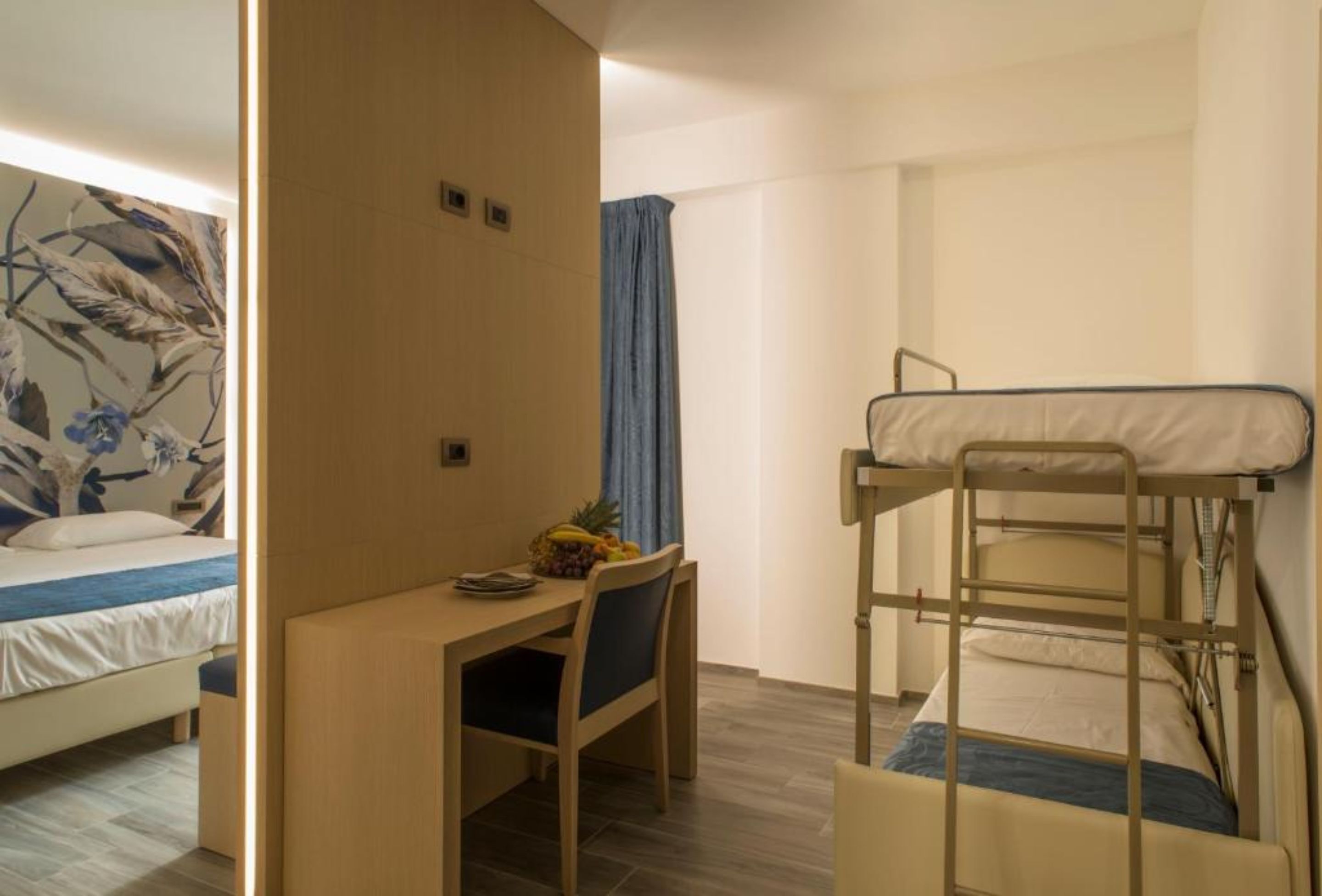 Une chambre avec des lits superposés, un bureau et une chaise.