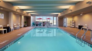 An indoor swimming pool with clear depth markers, lounge chairs, and umbrellas. - Home2 Suites by Hilton Baltimore / Aberdeen, MD (Aberdeen)