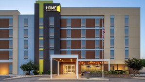 A multi-story hotel with a modern facade, featuring a prominent 'HOME 2' sign. The entrance is accessible via a covered walkway, and the building is equipped with large windows and a flagpole. - Home2 Suites by Hilton Baltimore / Aberdeen, MD (Aberdeen)